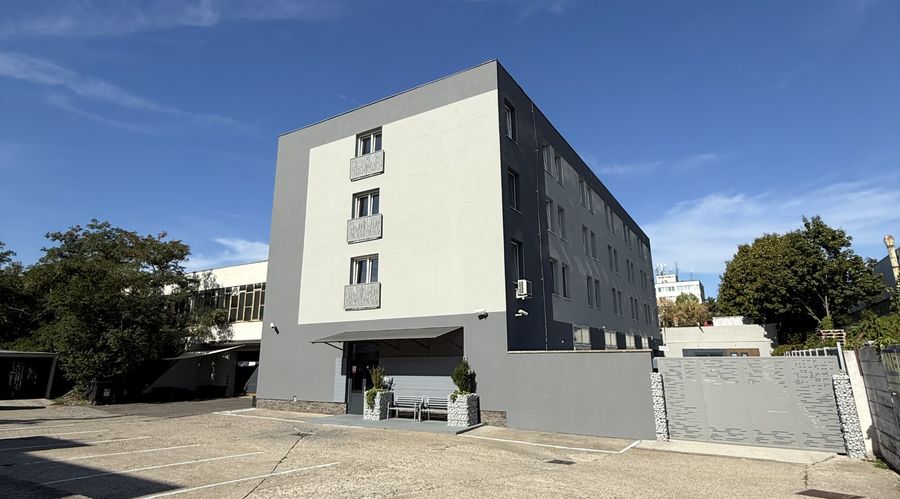 Budova ubytovania Fér Bývanie na ulici Polianky 15 v Bratislave – Dúbravke s parkoviskom pred vchodom